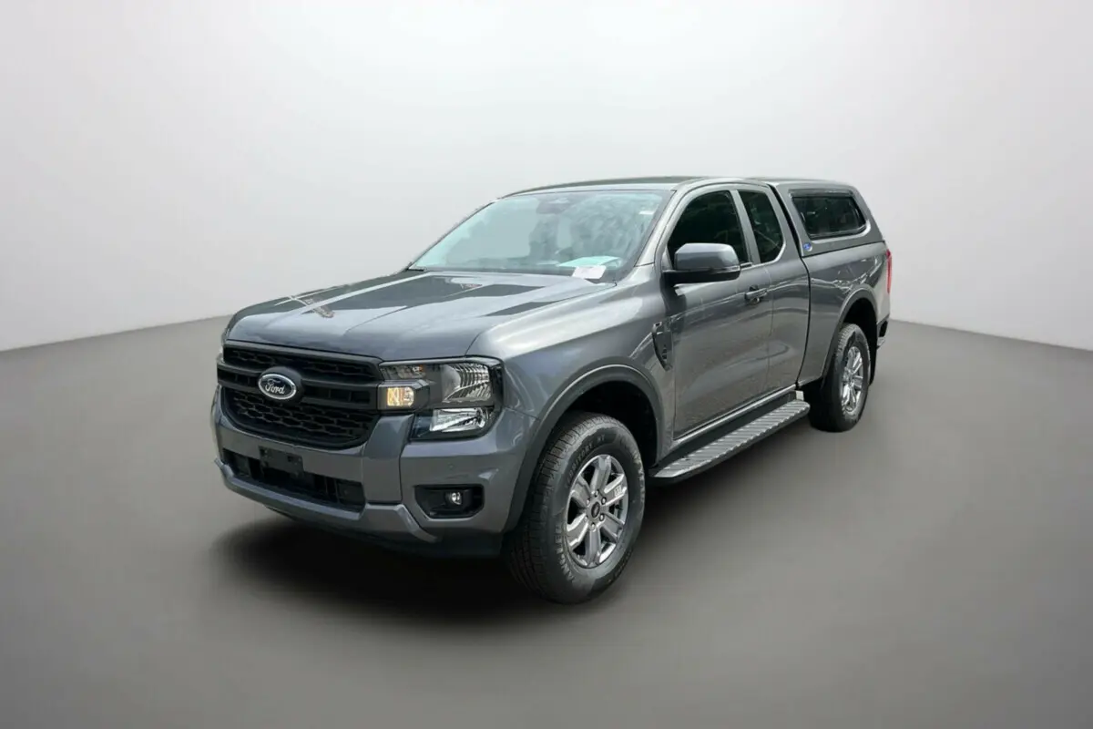 Ford Ranger gris carbone en 3/4 avant droit avec hard-top et marchepieds latéraux visibles.