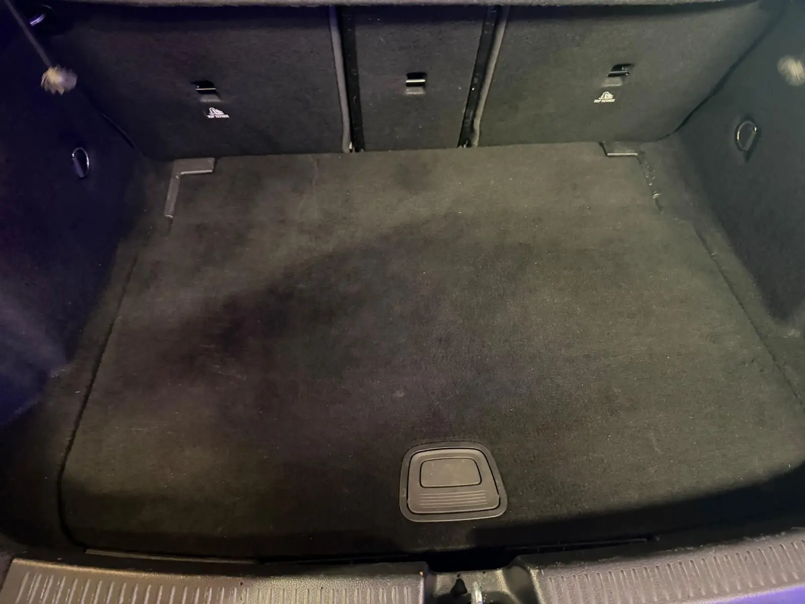 Vue intérieure du coffre noir de la Mercedes Classe A 220D AMG Line blanc, espace de chargement propre et vide.