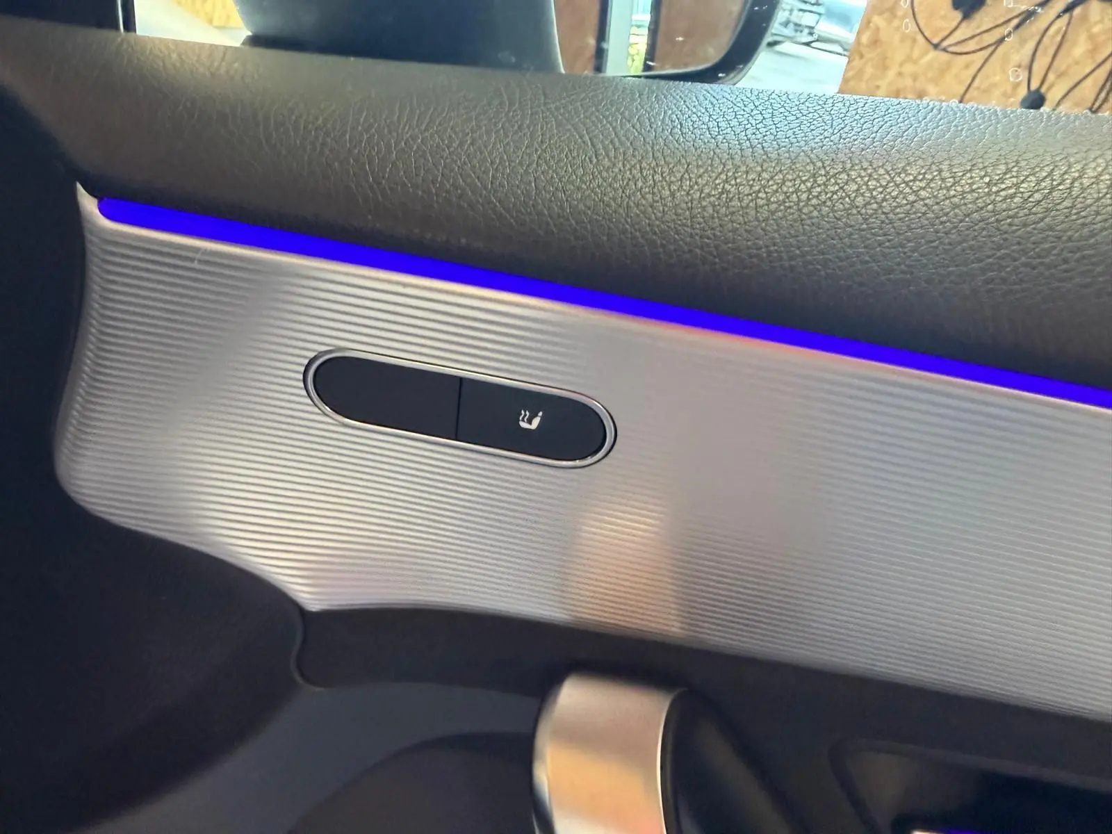 Détail de la commande de siège chauffant sur la porte côté gauche d’une Mercedes Classe A 220D AMG Line blanche.