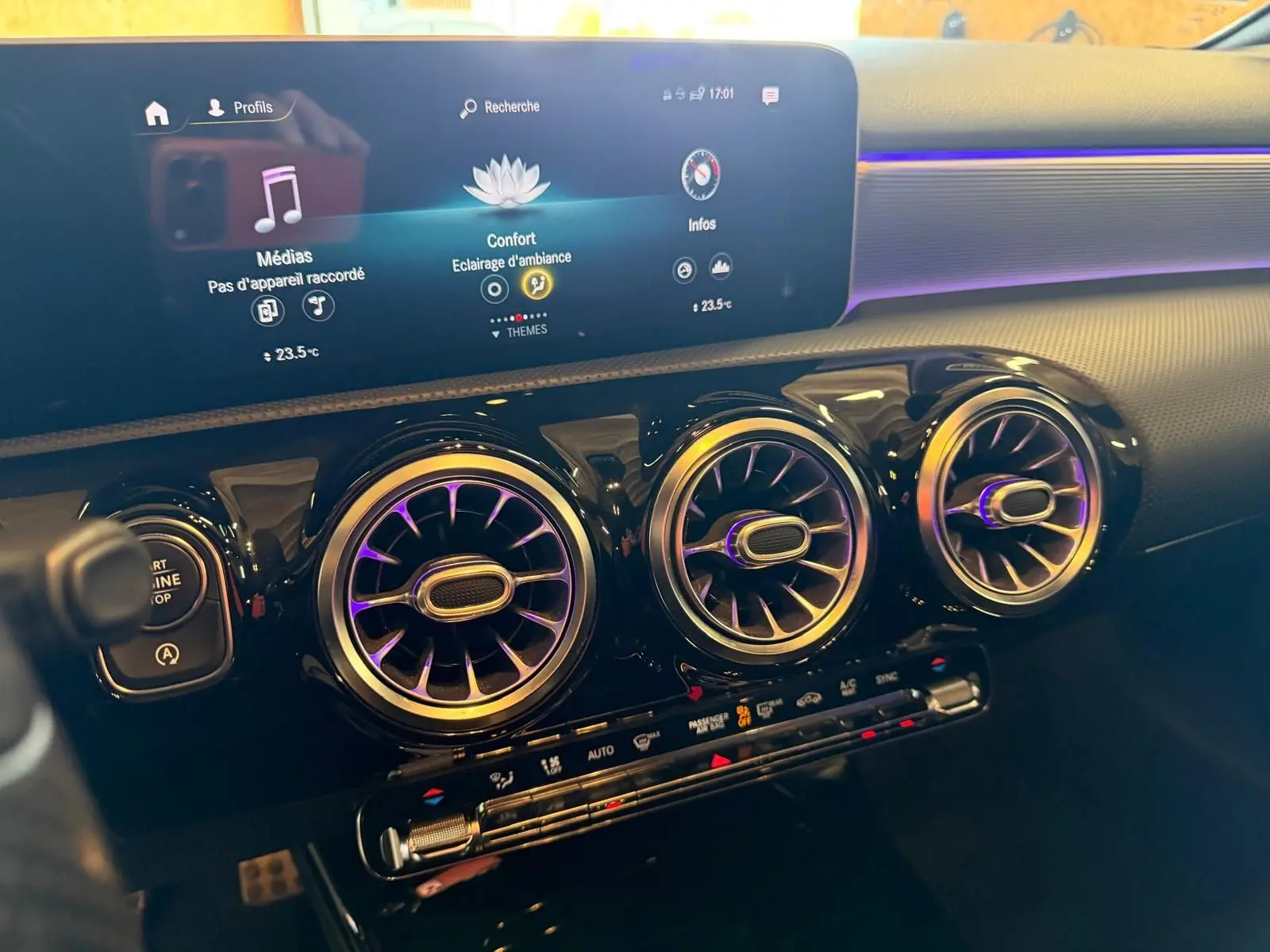 Vue rapprochée du tableau de bord noir de la Mercedes Classe A 220D AMG Line 2019 avec aérateurs ronds et écran digital.