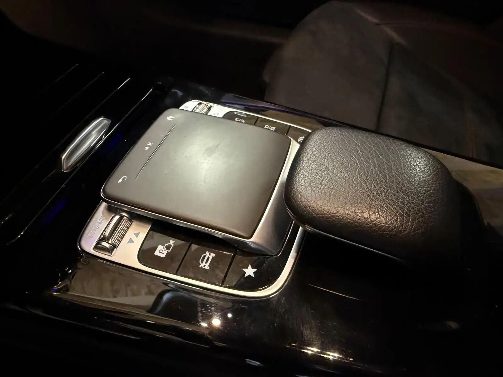 Gros plan sur la console centrale noire de la Mercedes Classe A 220D AMG Line 2019, montrant le pavé tactile et le repose-poignet en cuir.