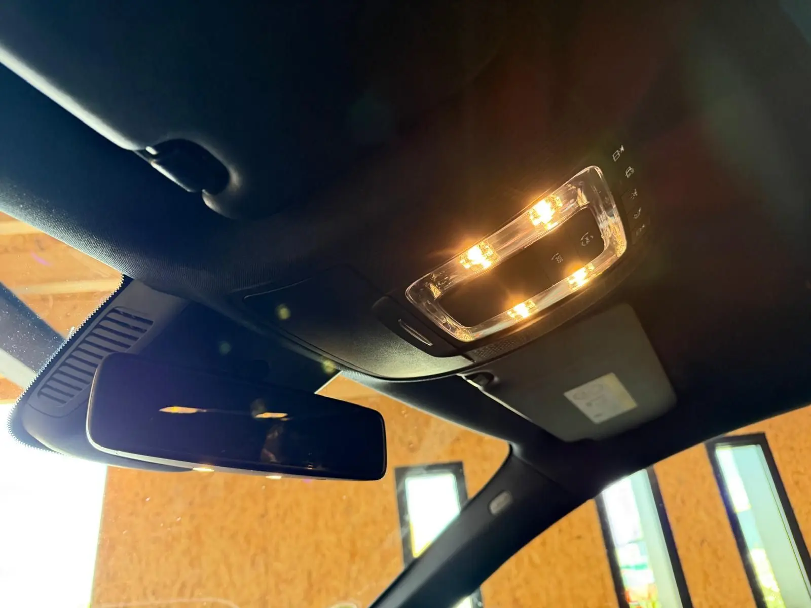 Vue intérieure du plafonnier et du rétroviseur intérieur d’une Mercedes Classe A 220D AMG Line de 2019 avec toit noir.