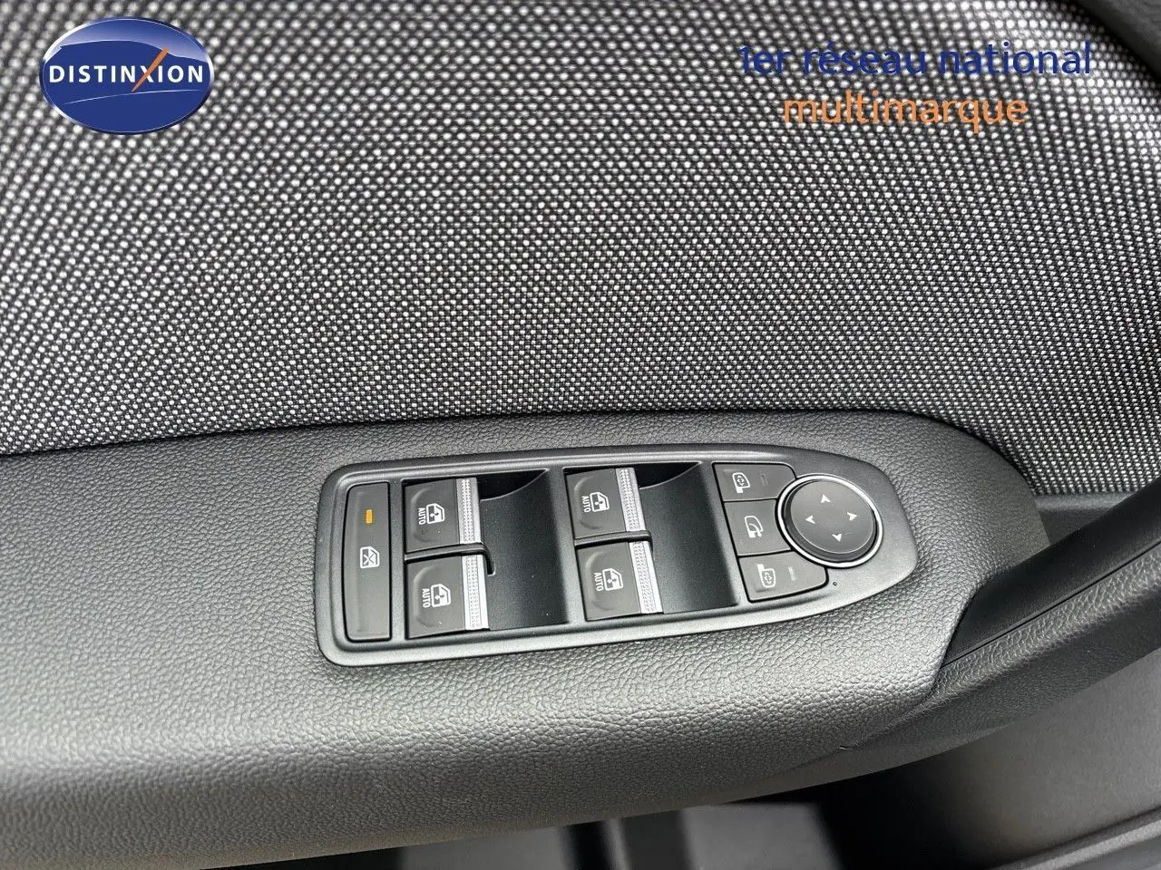 Gros plan sur les commandes des vitres électriques côté gauche d'une Renault Captur gris Rafale métal avec toit noir.