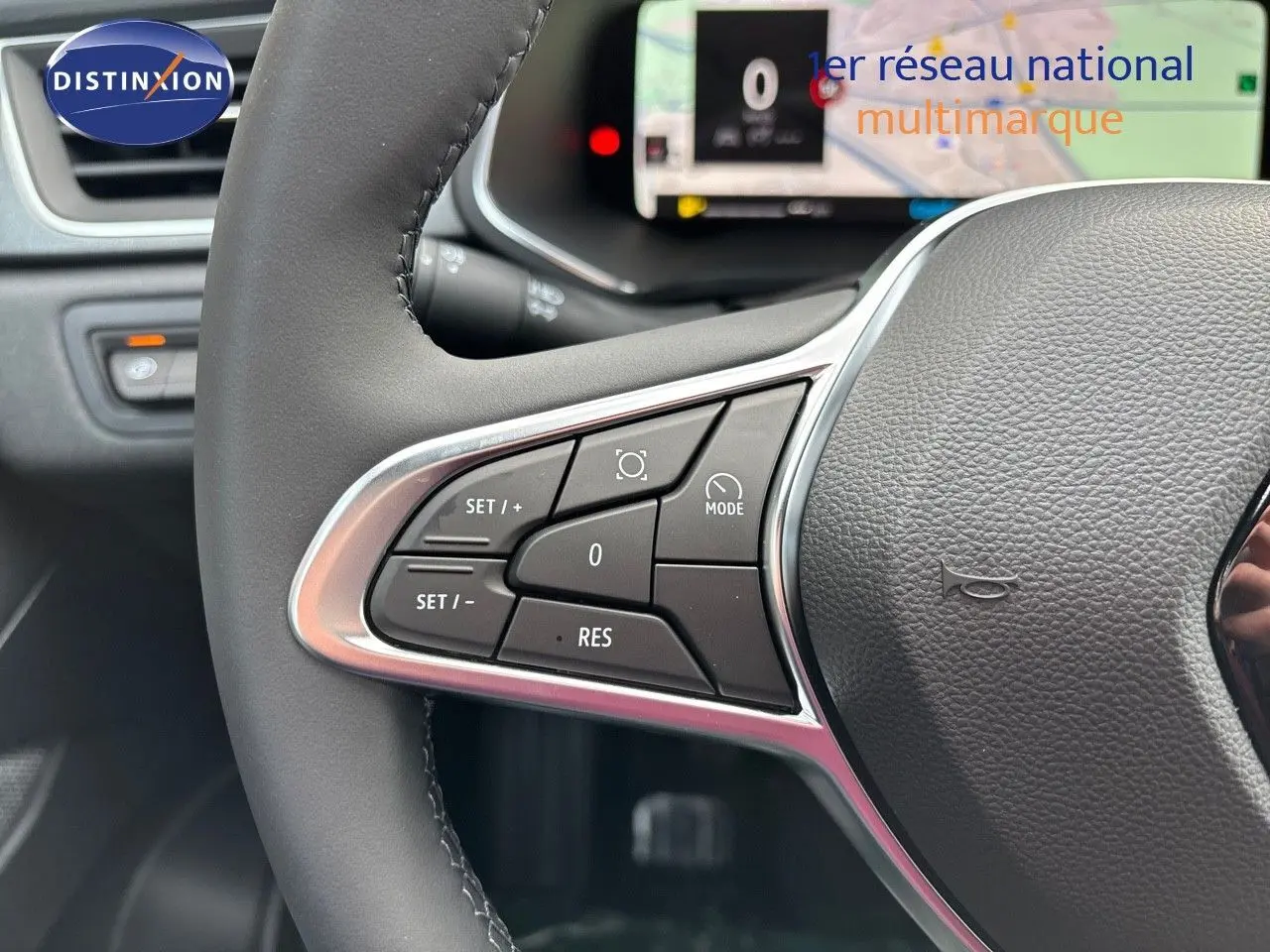 Gros plan sur les commandes au volant à gauche du Renault Captur II gris rafale métal avec toit noir, tableau de bord numérique en arrière-plan.