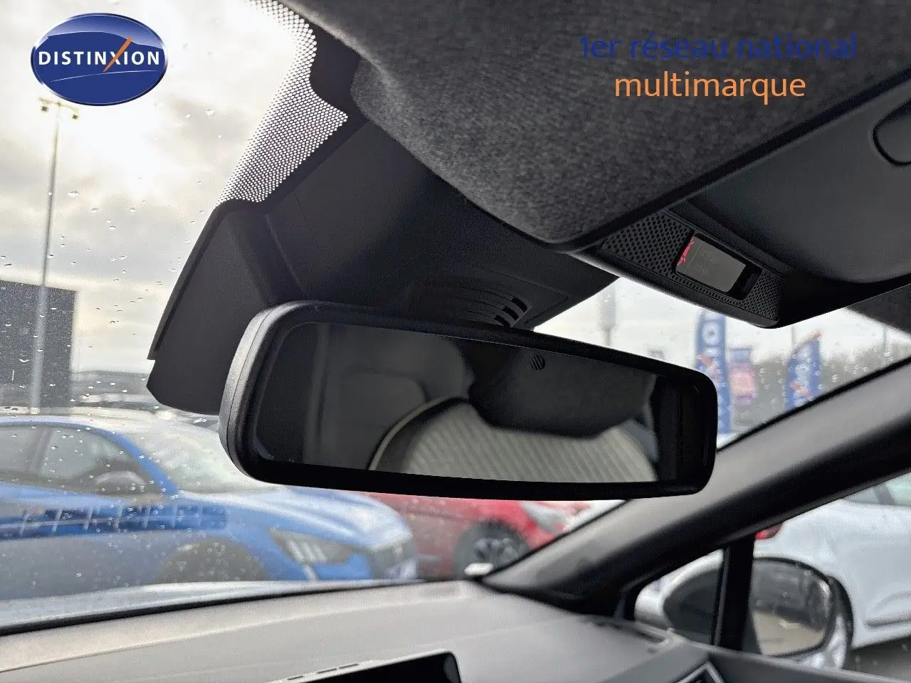 Vue intérieure du rétroviseur central d’un Renault Captur gris Rafale métal avec toit noir, montrant l’arrière du siège conducteur.