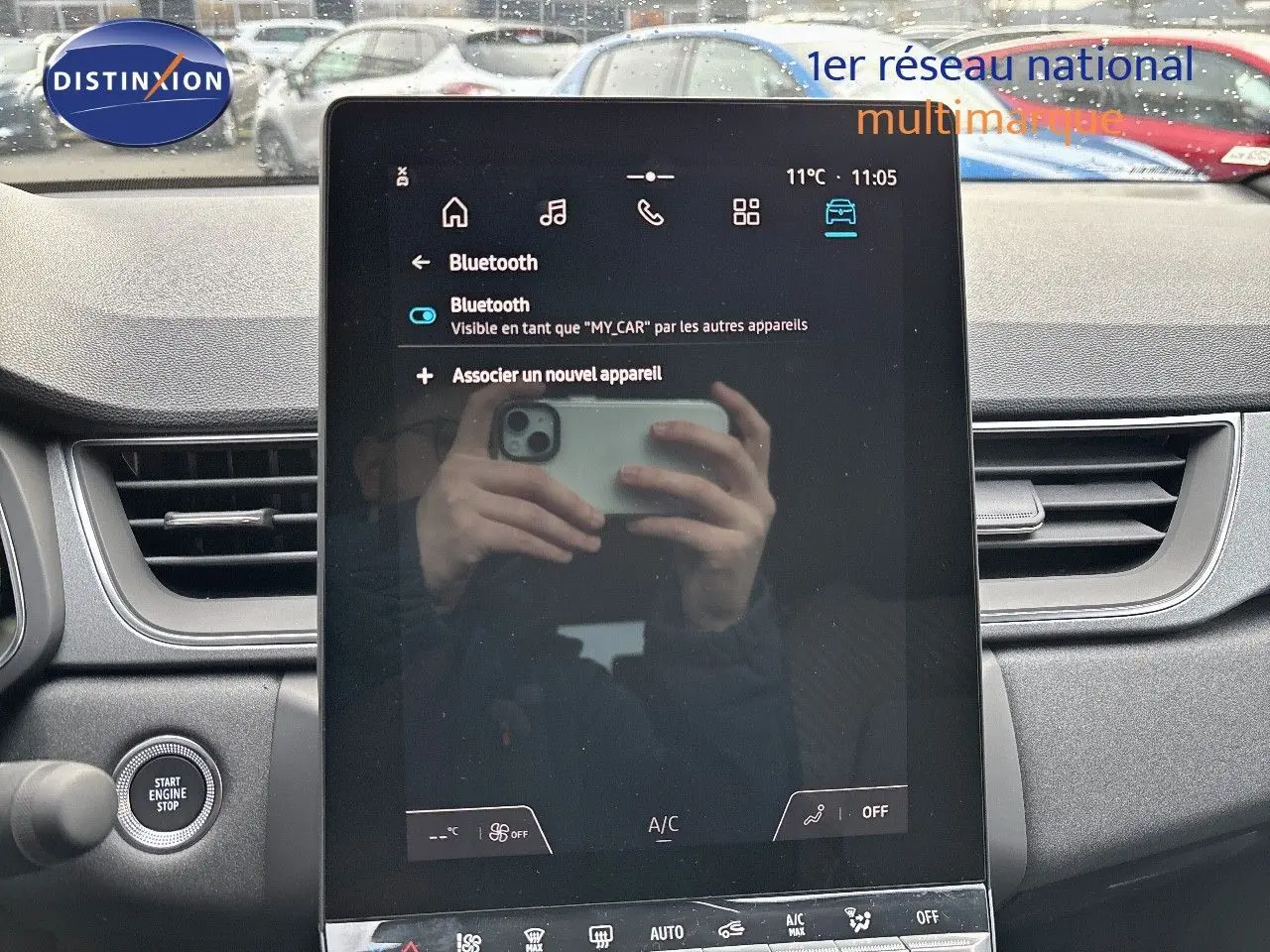 Vue de face de l'écran tactile central du Renault Captur gris Rafale métal, avec tableau de bord et bouton start visible.