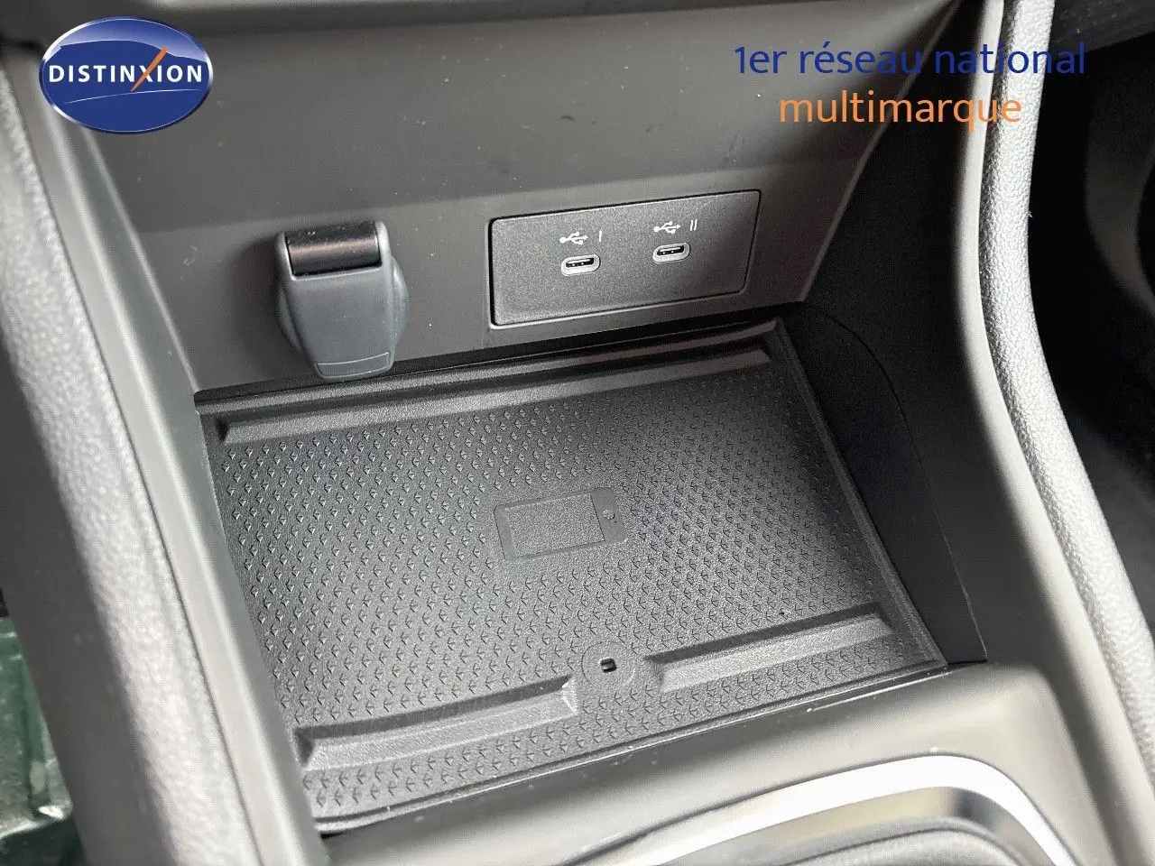 Gros plan sur la console centrale du Renault Captur II hybride, montrant les ports USB-C et un espace de rangement noir texturé.