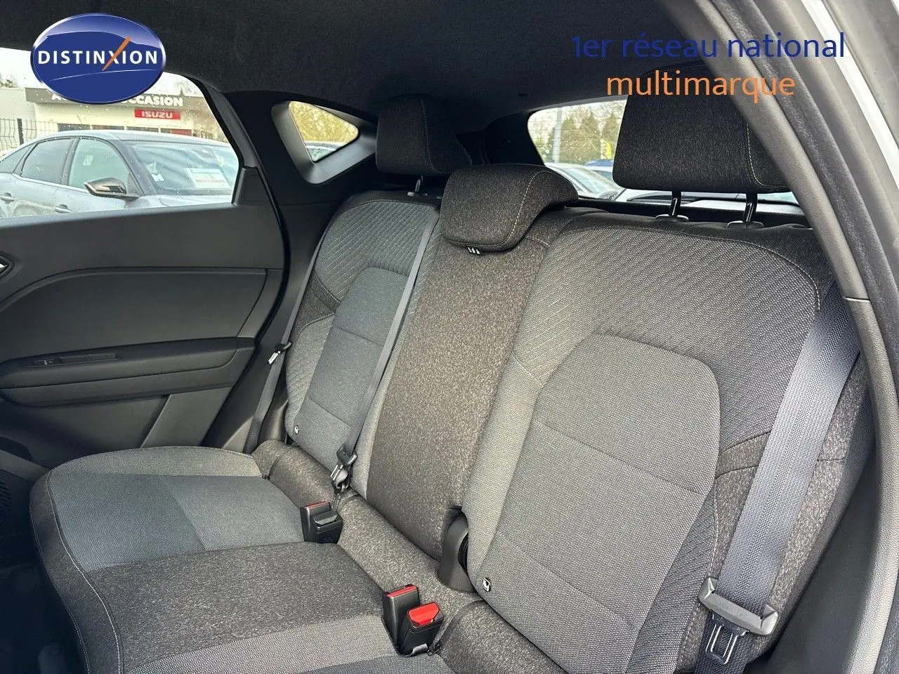 Vue intérieure arrière du Renault Captur II hybride 2025, montrant les sièges arrière en tissu gris foncé.