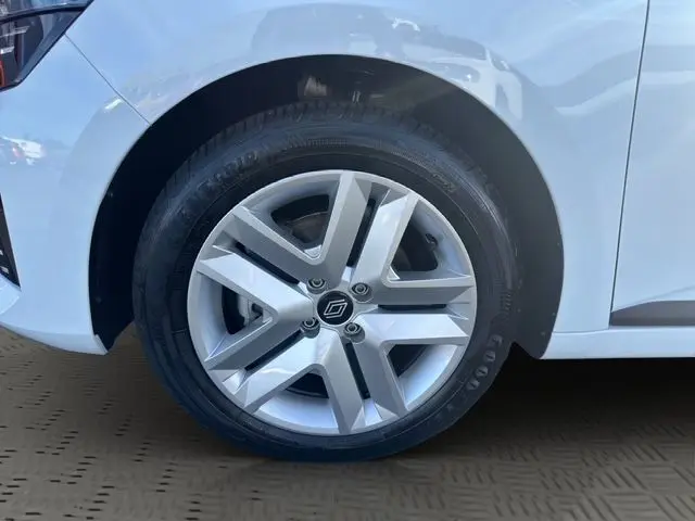 Gros plan sur la roue avant gauche blanche d'une Renault Clio V avec jante alliage argentée et logo Renault central.