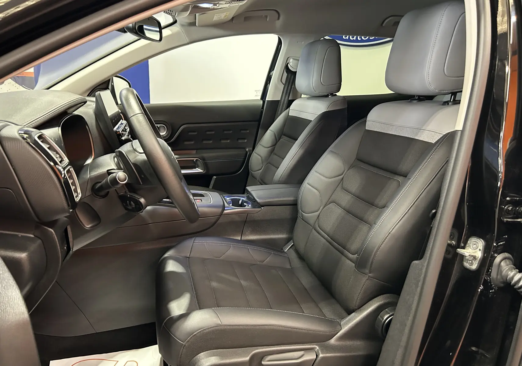 Vue intérieure côté conducteur du Citroën C5 Aircross noir Perla Nera, sièges cuir noir et tableau de bord moderne.