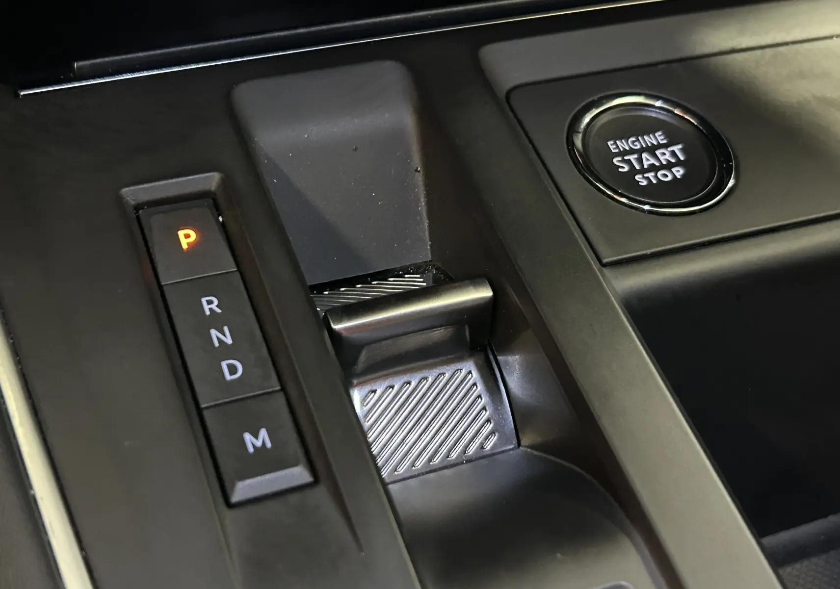 Gros plan sur la console centrale noire du Citroën C5 Aircross 2024, avec levier de vitesses automatique et bouton start/stop.