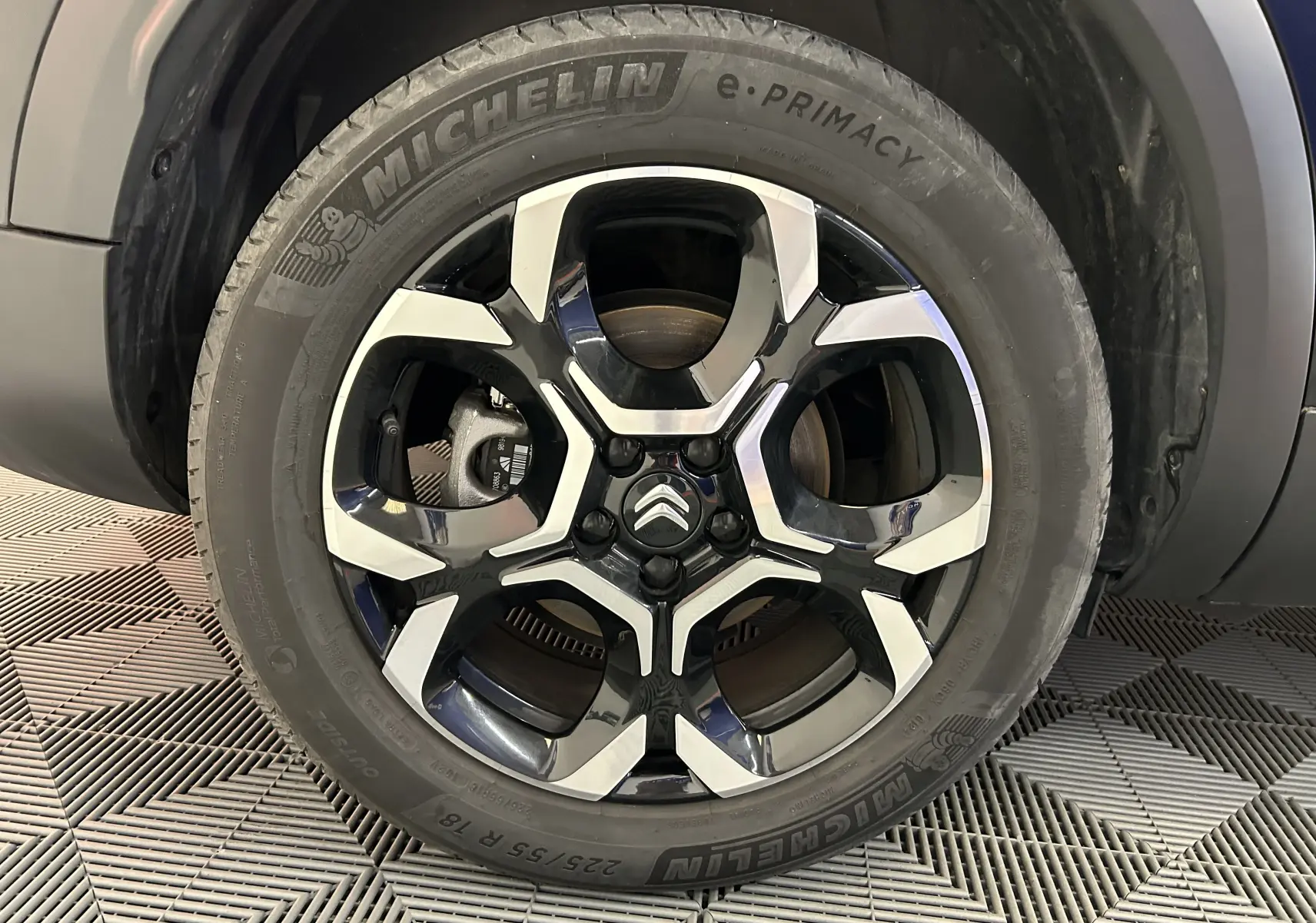 Gros plan sur la roue avant gauche du Citroën C5 Aircross noir Perla Nera, jante alliage bicolore et pneu Michelin.