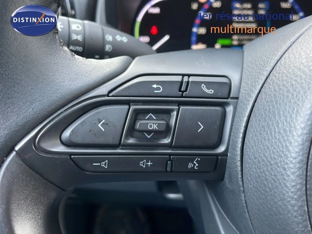 Gros plan sur les commandes multifonctions à gauche du volant de la Toyota Yaris Cross Hybrid blanche de 2024.