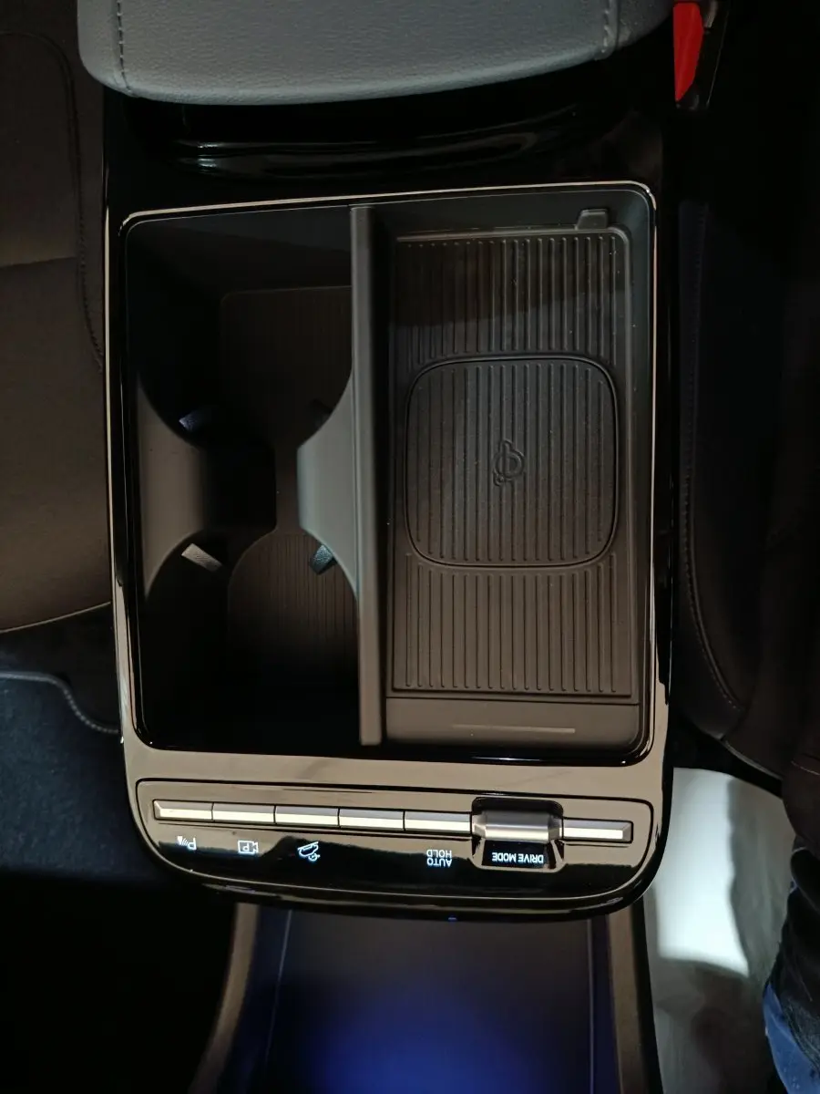 Vue plongeante sur la console centrale noire du Hyundai Tucson 2025, avec zone de recharge sans fil et commandes tactiles.