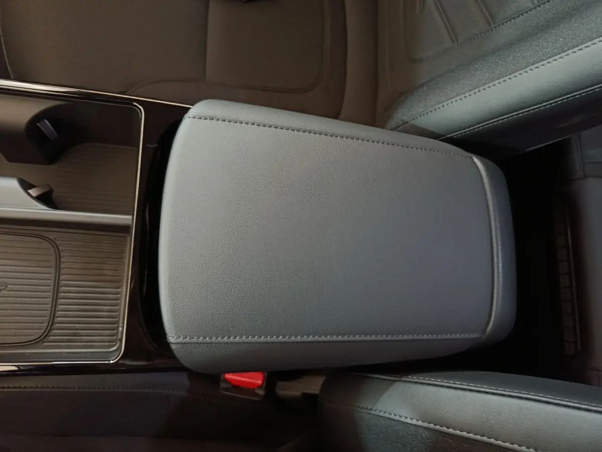 Détail de l'accoudoir central en cuir gris foncé du Hyundai Tucson 2025, avec console de rangement adjacente.