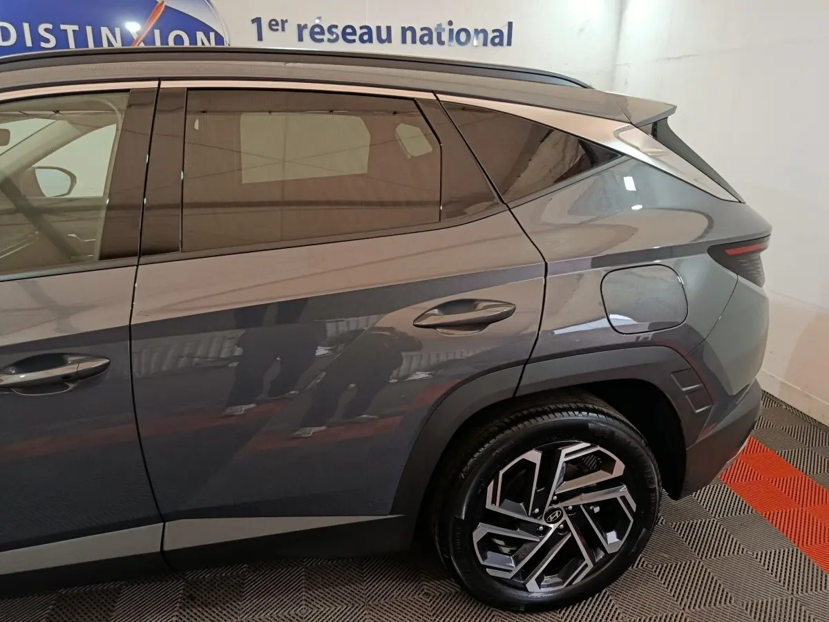 Vue latérale droite du Hyundai Tucson 1.6 Hybrid 239 Creative gris foncé, mettant en valeur la jante au design moderne.