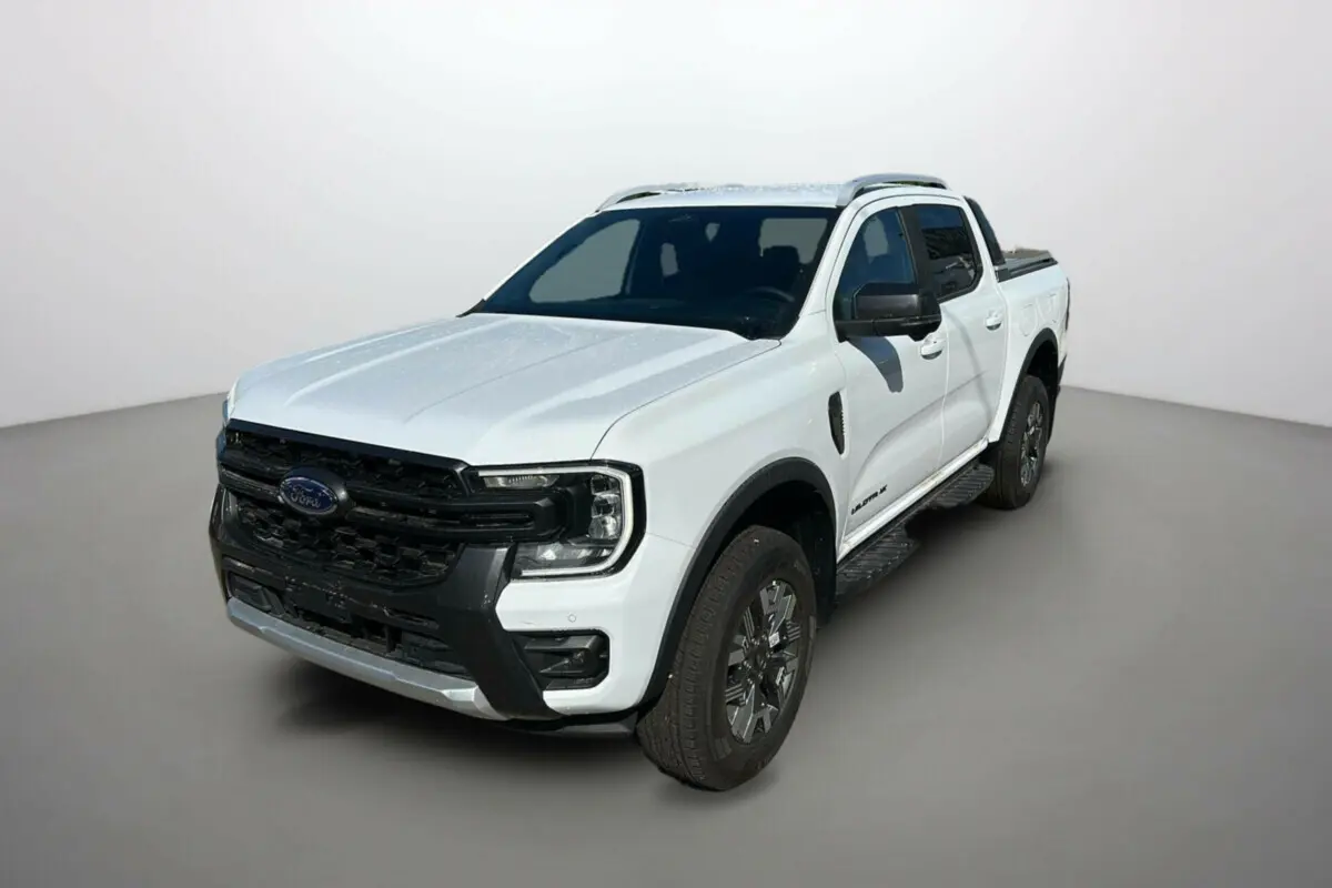 Ford Ranger blanc en vue 3/4 avant droit avec calandre noire et barres de toit visibles.