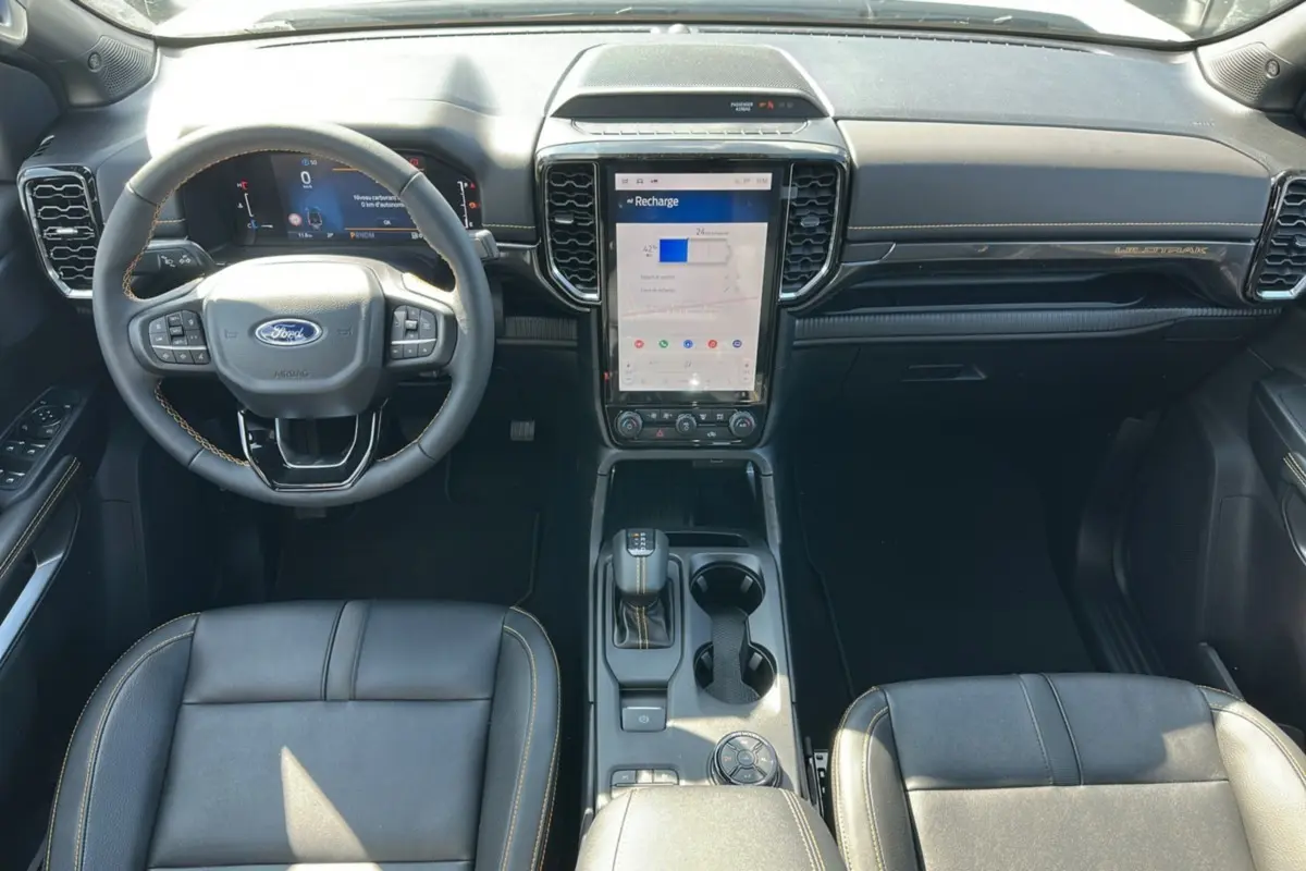 Vue intérieure frontale du Ford Ranger Wildtrak 2026, montrant le volant cuir multifonctions et l’écran tactile central vertical.