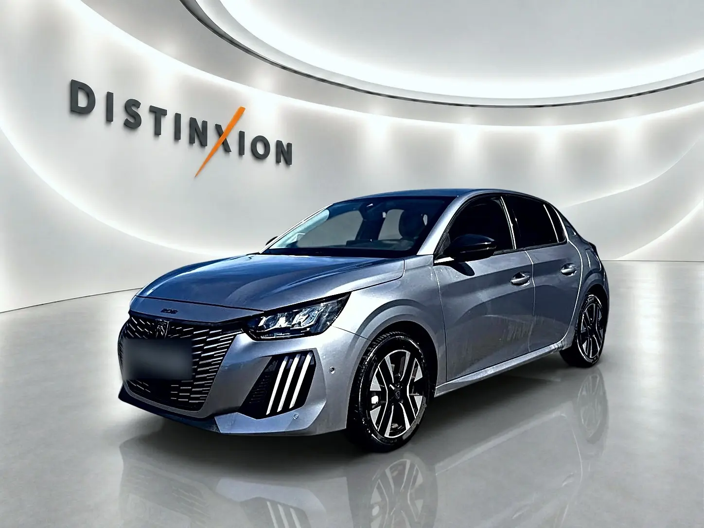 Peugeot 208 gris Artense vue 3/4 avant droit, avec phares LED et jantes alliage distinctives.