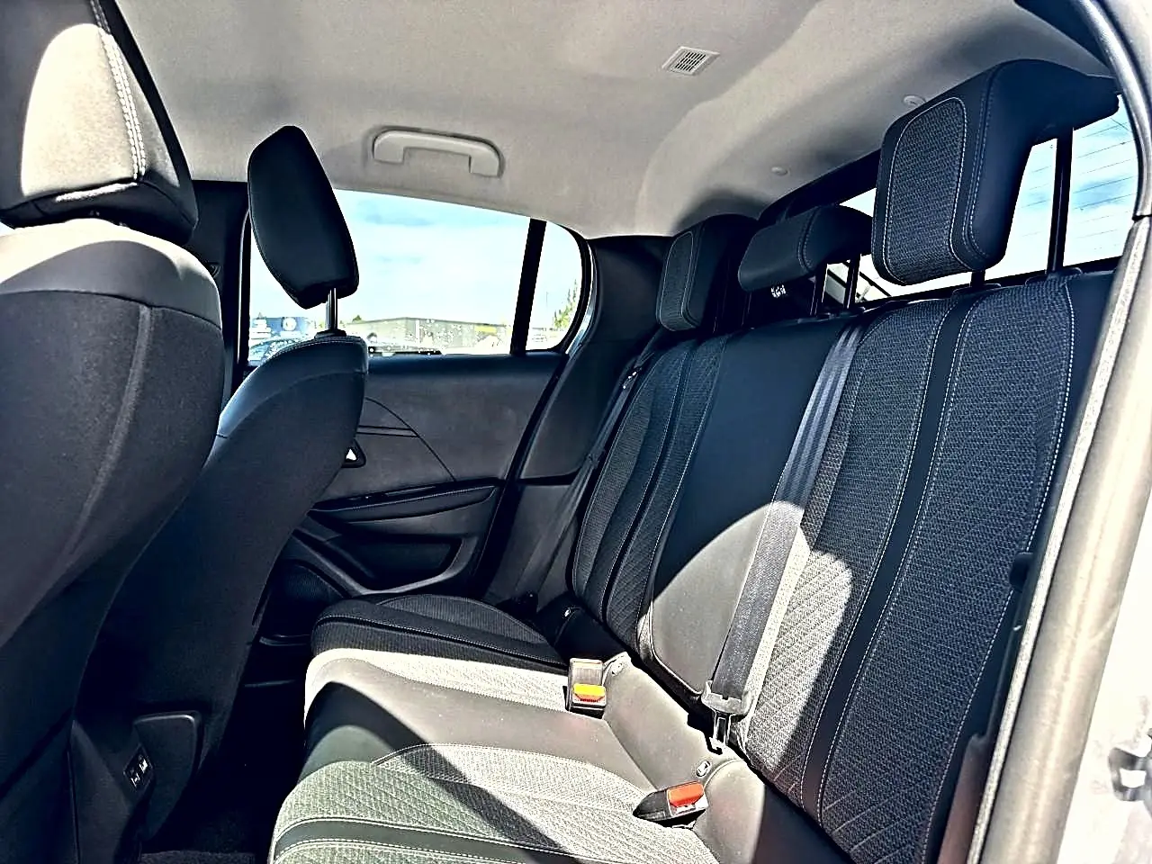 Vue intérieure côté droit des sièges arrière en tissu gris foncé de la Peugeot 208 1.2 100 Allure 2025.