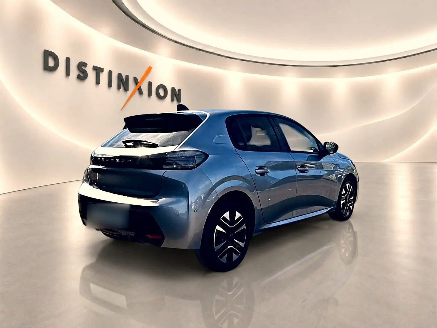 Vue 3/4 arrière droite d'une Peugeot 208 1.2 100 Allure gris artense dans un showroom lumineux.