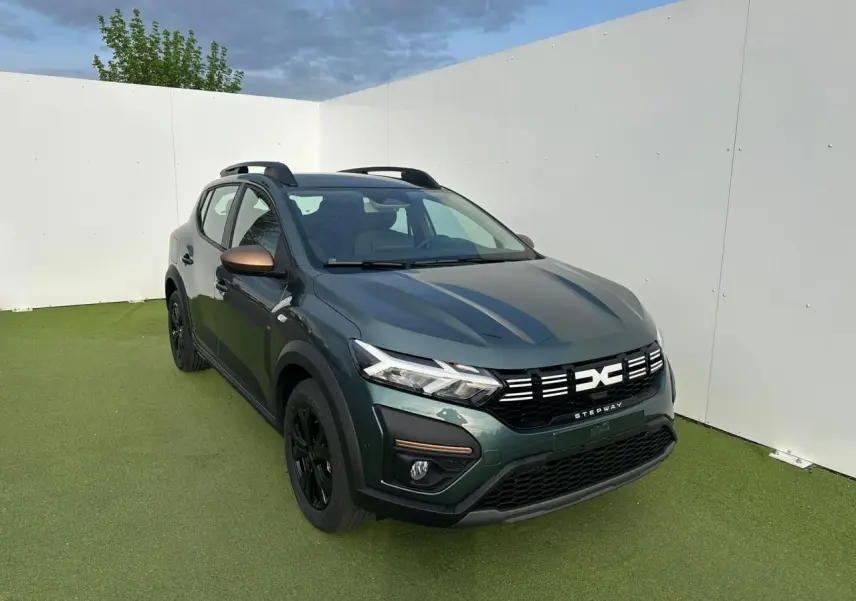 Vue 3/4 avant droit d'une Dacia Sandero III Stepway 2025 vert cèdre avec détails brun cuivré et jantes noires.