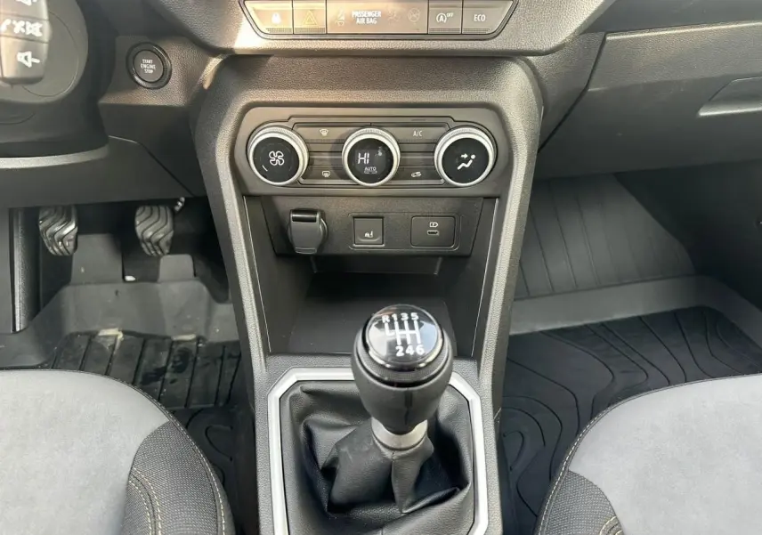 Vue intérieure centrée sur la console centrale et levier de vitesses manuel de la Dacia Sandero III Stepway 2025.