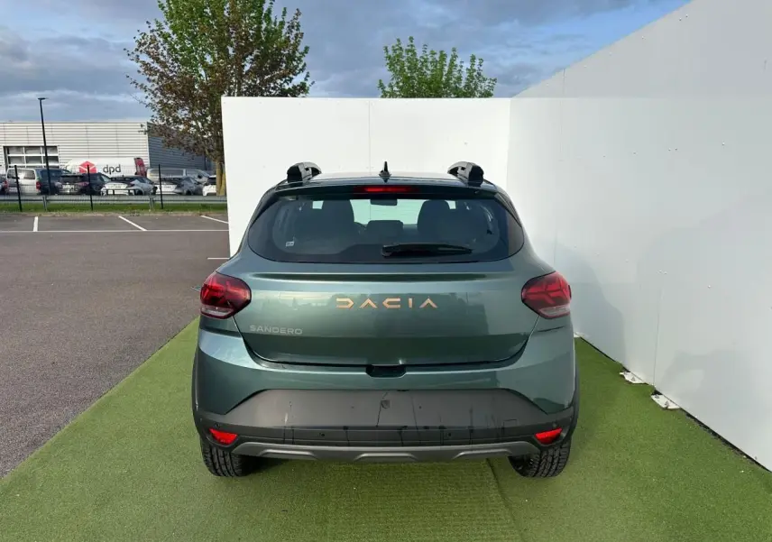 Vue arrière d'une Dacia Sandero III Stepway vert cèdre avec logo et feux arrière LED visibles.