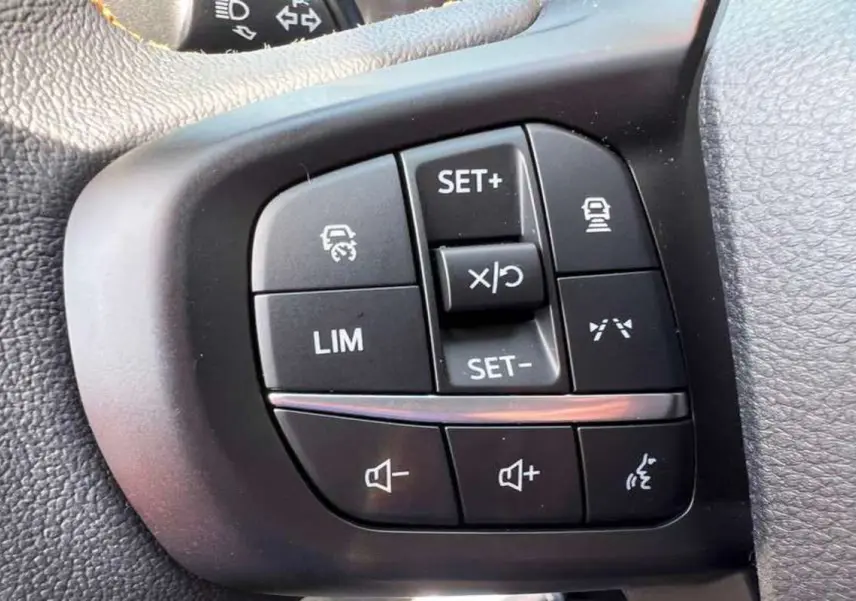 Gros plan sur les commandes de régulateur et volume au volant du Ford Ranger Wildtrak noir agate.