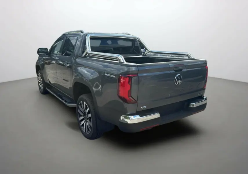 Volkswagen Amarok V6 gris foncé en 3/4 arrière droit avec arceaux inox et jantes alu 21 pouces.
