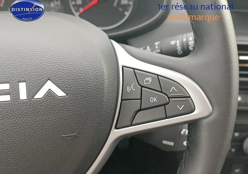 Gros plan sur les commandes au volant à droite de la DACIA SANDERO noire 2025, avec boutons multifonctions visibles.