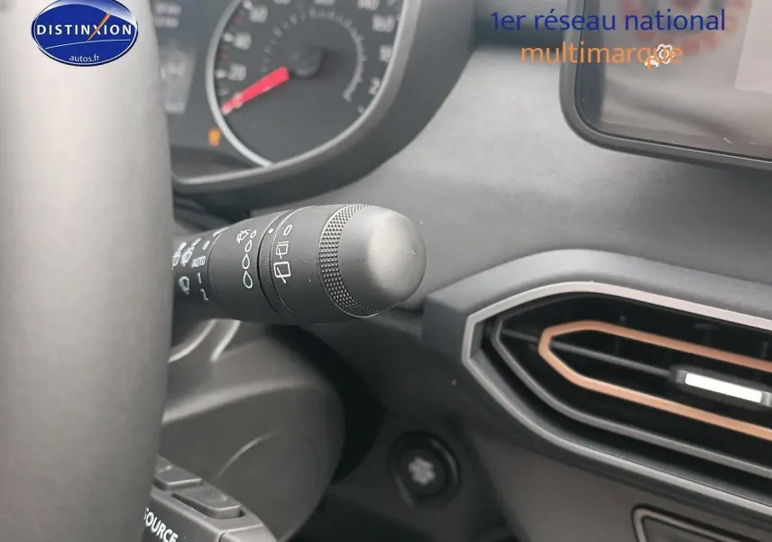 Détail du commodo d'essuie-glace et de l'aération avec insert cuivre dans le tableau de bord de la Dacia Sandero noire 2025.