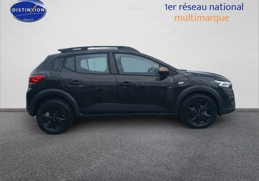 Profil côté gauche d'une Dacia Sandero Stepway noire 2025 avec barres de toit et jantes noires.