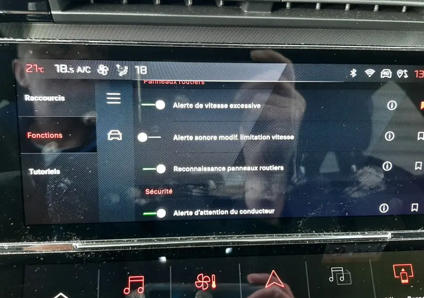 Vue rapprochée de l’écran tactile central de la Peugeot 308 SW blanc Okenite, affichant les réglages d’alerte et de sécurité.