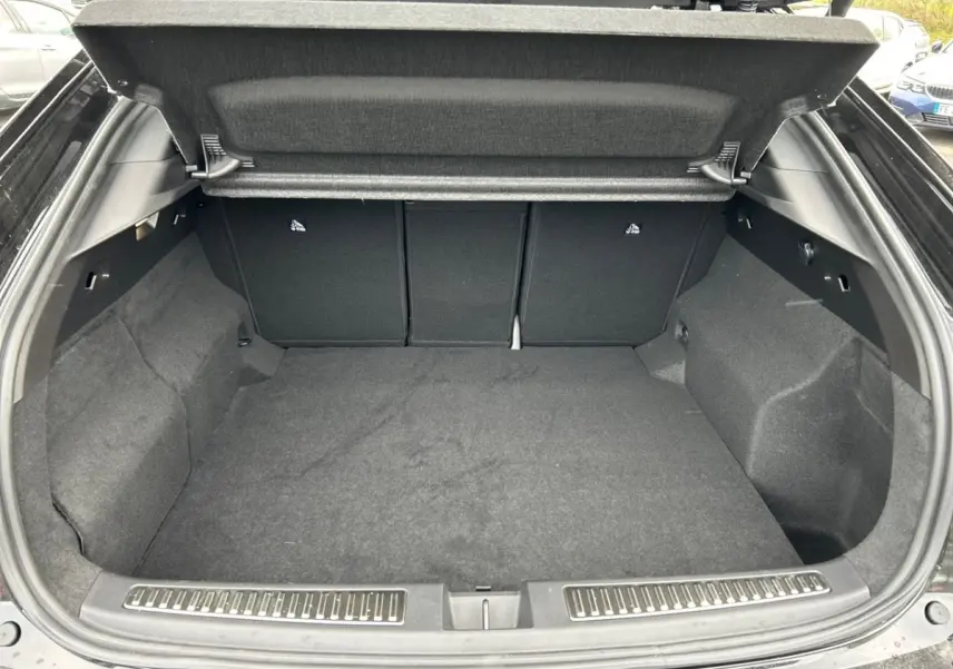 Coffre ouvert noir de la Renault Rafale esprit Alpine full hybrid E-Tech 200, vue intérieure spacieuse et propre.