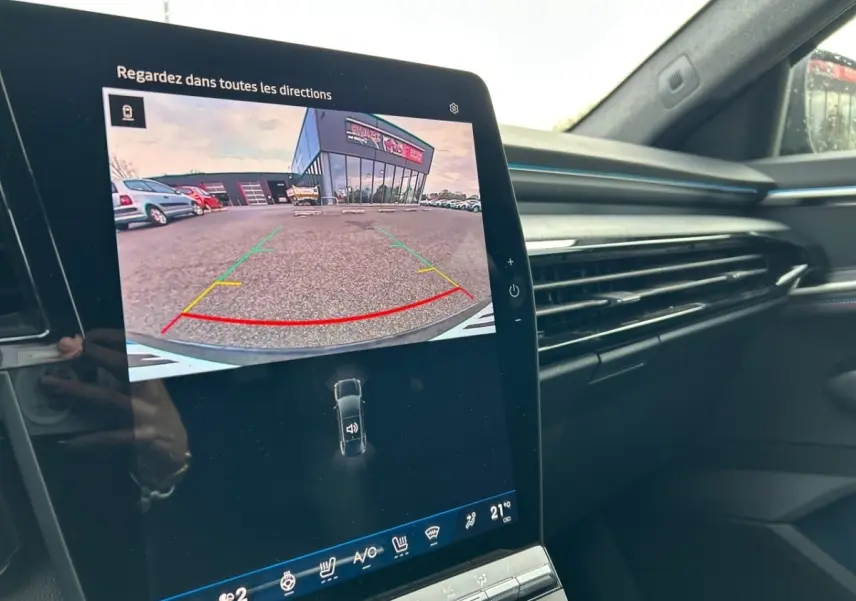 Vue intérieure du tableau de bord de la Renault Rafale noir, avec écran tactile affichant la caméra de recul en marche.