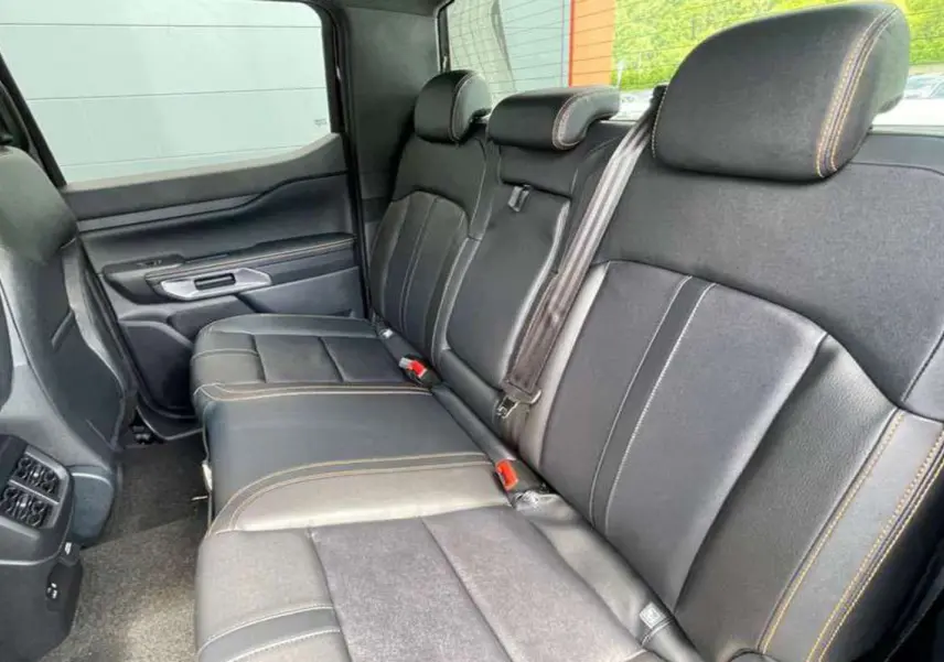 Vue intérieure côté droit des sièges arrière en cuir noir avec surpiqûres jaunes du Ford Ranger Wildtrak Plus 2025.