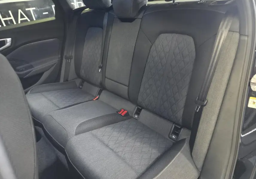 Vue intérieure du siège arrière tissu noir avec surpiqûres beige de l'Audi A5 Avant 2025 côté droit ouvert.