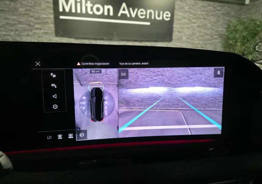 Écran MMI affichant la caméra avant et vue 360° d’une Audi A5 Avant noire en stationnement intérieur.