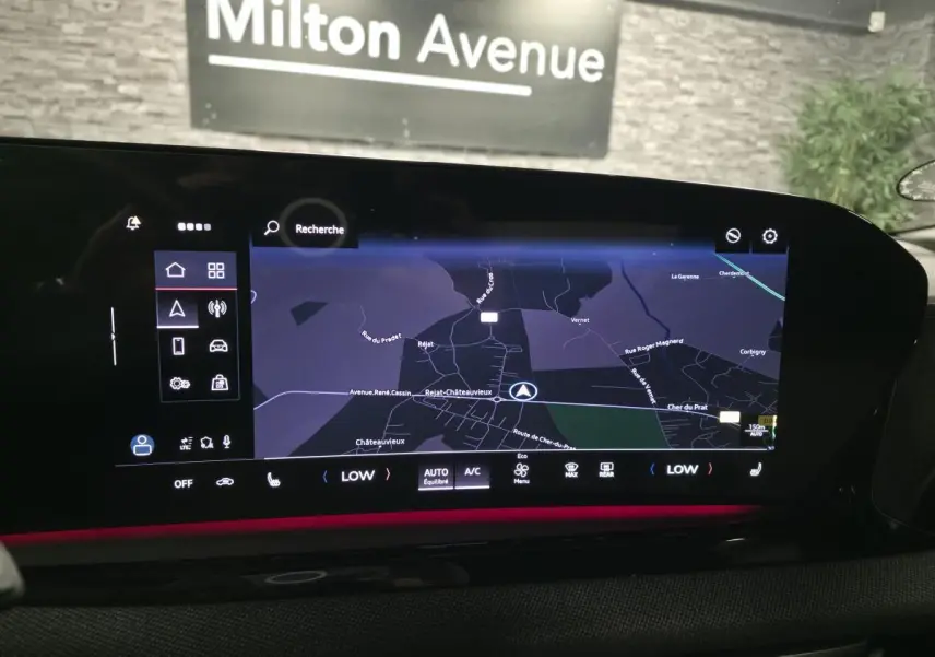 Vue rapprochée de l'écran MMI tactile de l'Audi A5 Avant noir, affichant la navigation et l'éclairage d'ambiance rouge.