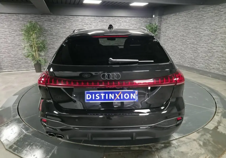 Vue arrière d'un break Audi A5 Avant noir avec feux arrière LED continus et double sortie d'échappement chromée.