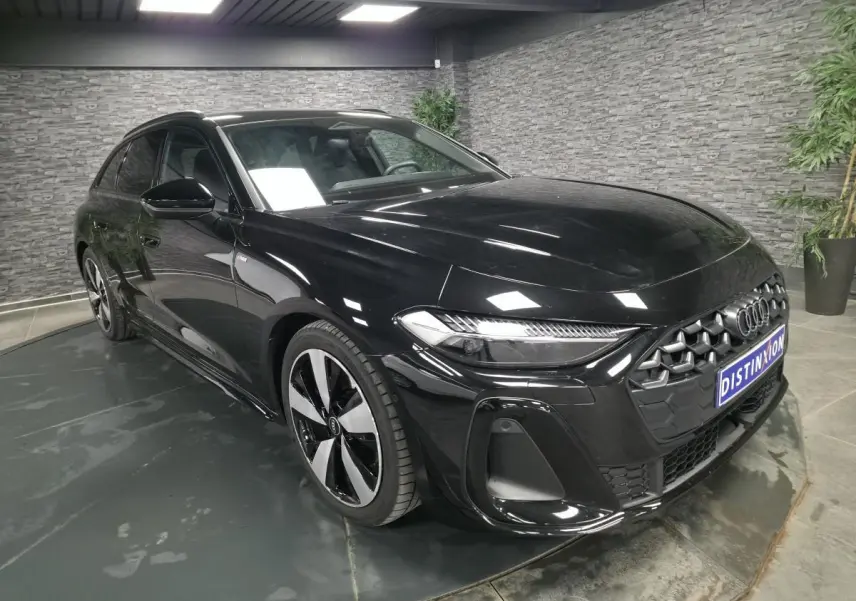 Audi A5 Avant noir vue 3/4 avant droit, avec jantes 19 pouces et calandre hexagonale distinctive S line.