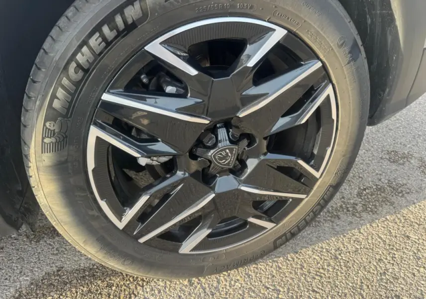 Gros plan sur la jante alliage noire et argentée de 19 pouces du Peugeot 3008 Hybrid 145 e-DCS6 gris.