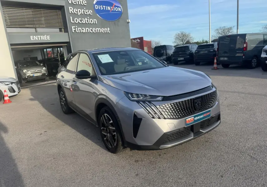 Peugeot 3008 Hybrid gris en 3/4 avant droit, avec calandre distinctive et jantes alliage 19 pouces visibles.