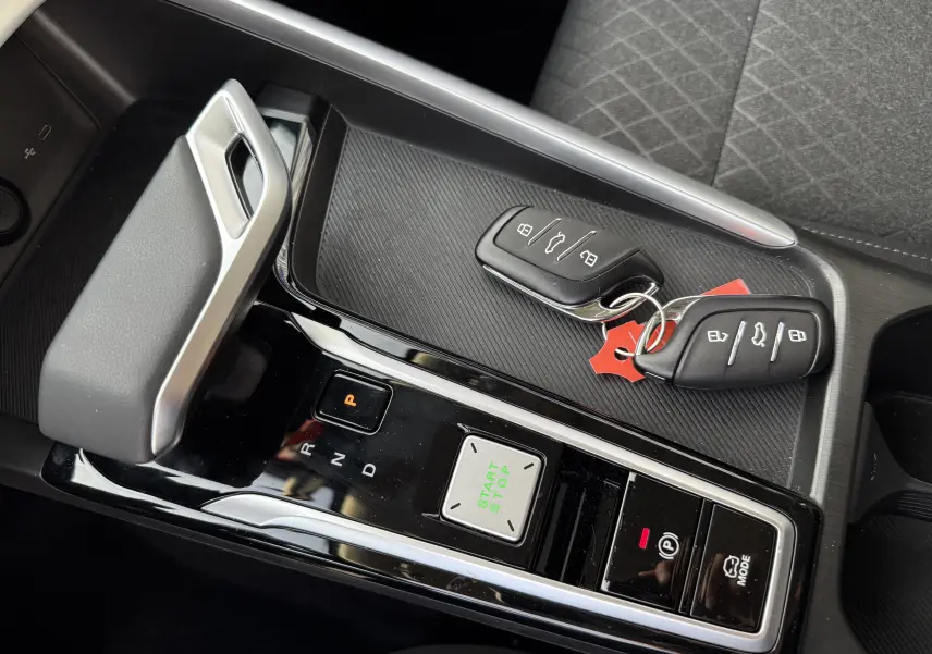 Gros plan sur la console centrale noire du MG ZS Hybrid 2026, avec clés, levier de vitesse et boutons start/stop visibles.