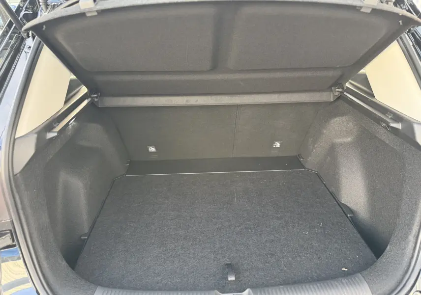 Coffre ouvert vu de l'arrière d'un MG Motor ZS Hybrid 197 Standard noir, montrant un espace de chargement propre et spacieux.