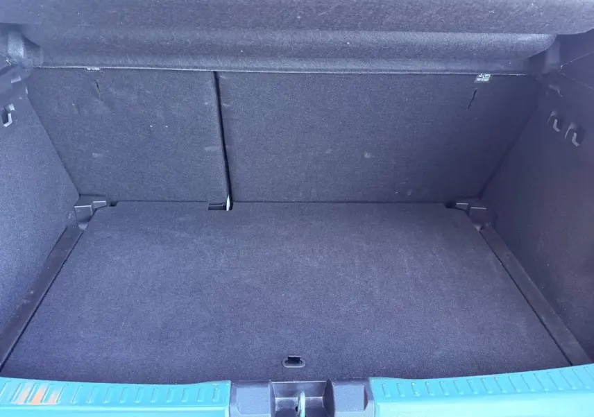 Vue intérieure du coffre spacieux et propre d'une Dacia Sandero 2025, avec revêtement noir uniforme.