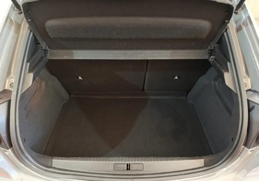 Coffre ouvert d'une Peugeot 208 gris foncé, vue de dessus montrant l'espace de rangement vide.