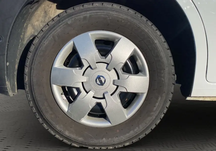 Gros plan sur la roue avant gauche du Nissan Interstar blanc, mettant en valeur la jante avec logo Nissan au centre.