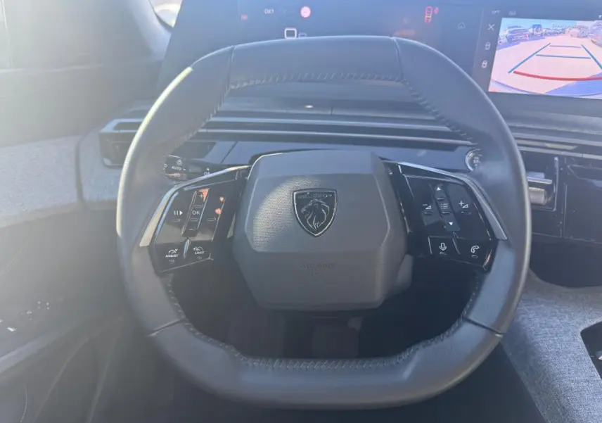 Vue frontale du volant cuir du Peugeot 3008 Hybrid 145 e-DCS6 Allure avec commandes intégrées et tableau de bord numérique.